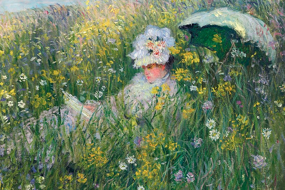 Een vrouw met een boek in een bloeiende weide vol bloemen.