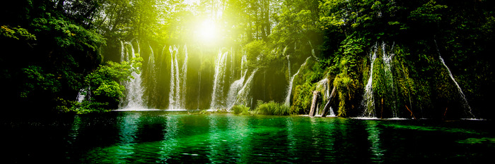 Waterval met zon en smaragdgroen water