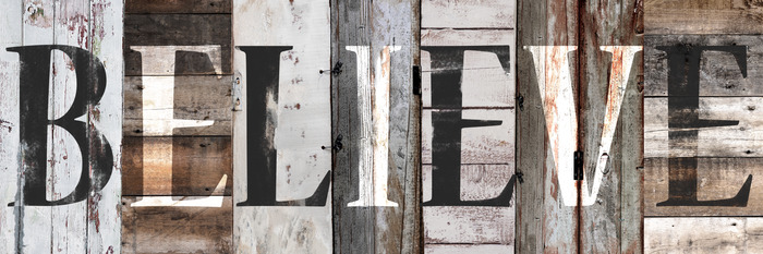 Het opschrift &quot;geloven&quot; op de achtergrond van de planken