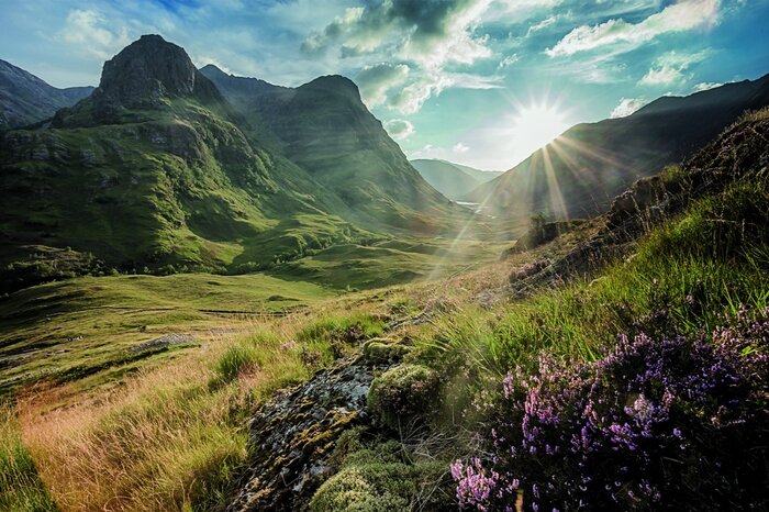 De stralen van de ochtendzon verlichten het berglandschap