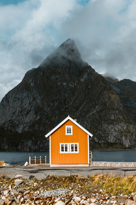 Een oranje huis tussen de bergen en de oceaan