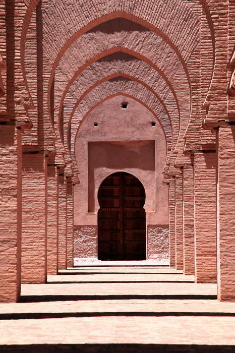 Symmetrische hal met bogen in warme tinten.